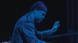 Jason in performance at piano under blue light